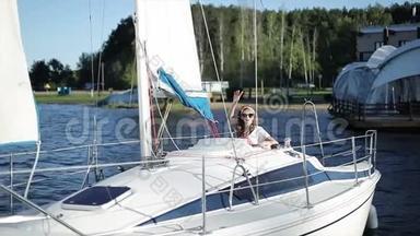 一个时髦的女孩从白色游艇上挥动她的手。